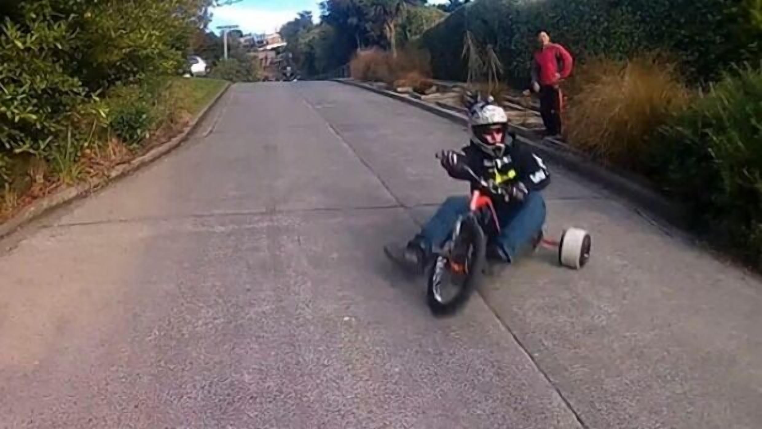 A person on a motorcycle on a paved road.