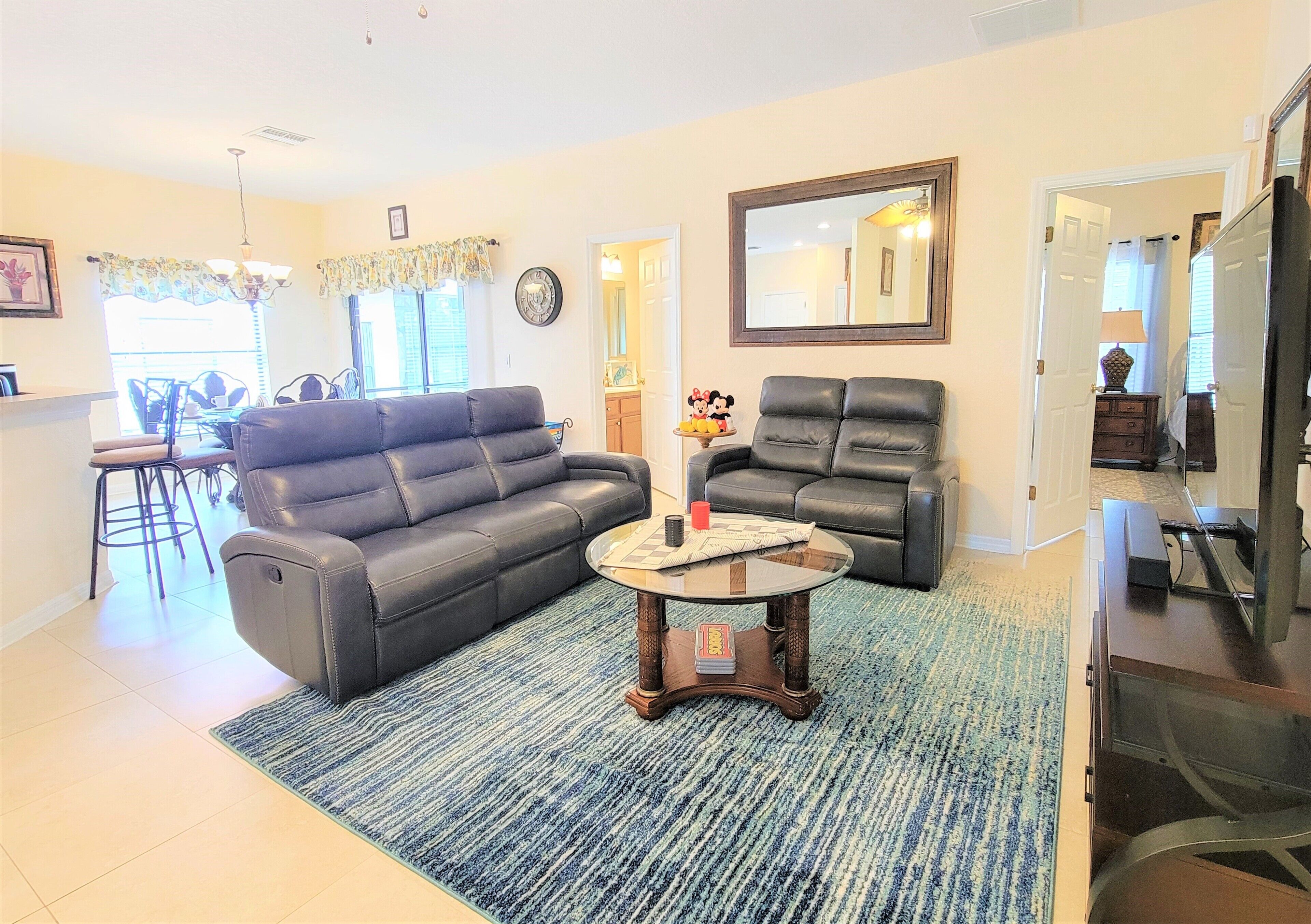 A living room with a sofa, armchairs, a coffee table, and a TV.