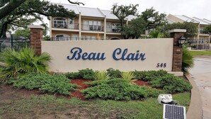 Une enseigne pour Beau Clair, un immeuble à plusieurs étages doté de balcons et d’une façade en briques.