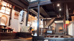 A traditional Japanese interior with tatami mats, a low table, and a shoe rack. - Monzen Okagero (Ikoma)