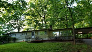 A single-story house with a front porch, a covered patio, and a well-maintained lawn.