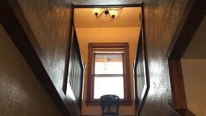 A staircase with wooden railings and a window at the top. - Historic Downtown Carriage House (Flagstaff)