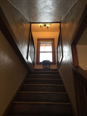 A staircase with wooden railings and a window at the top.