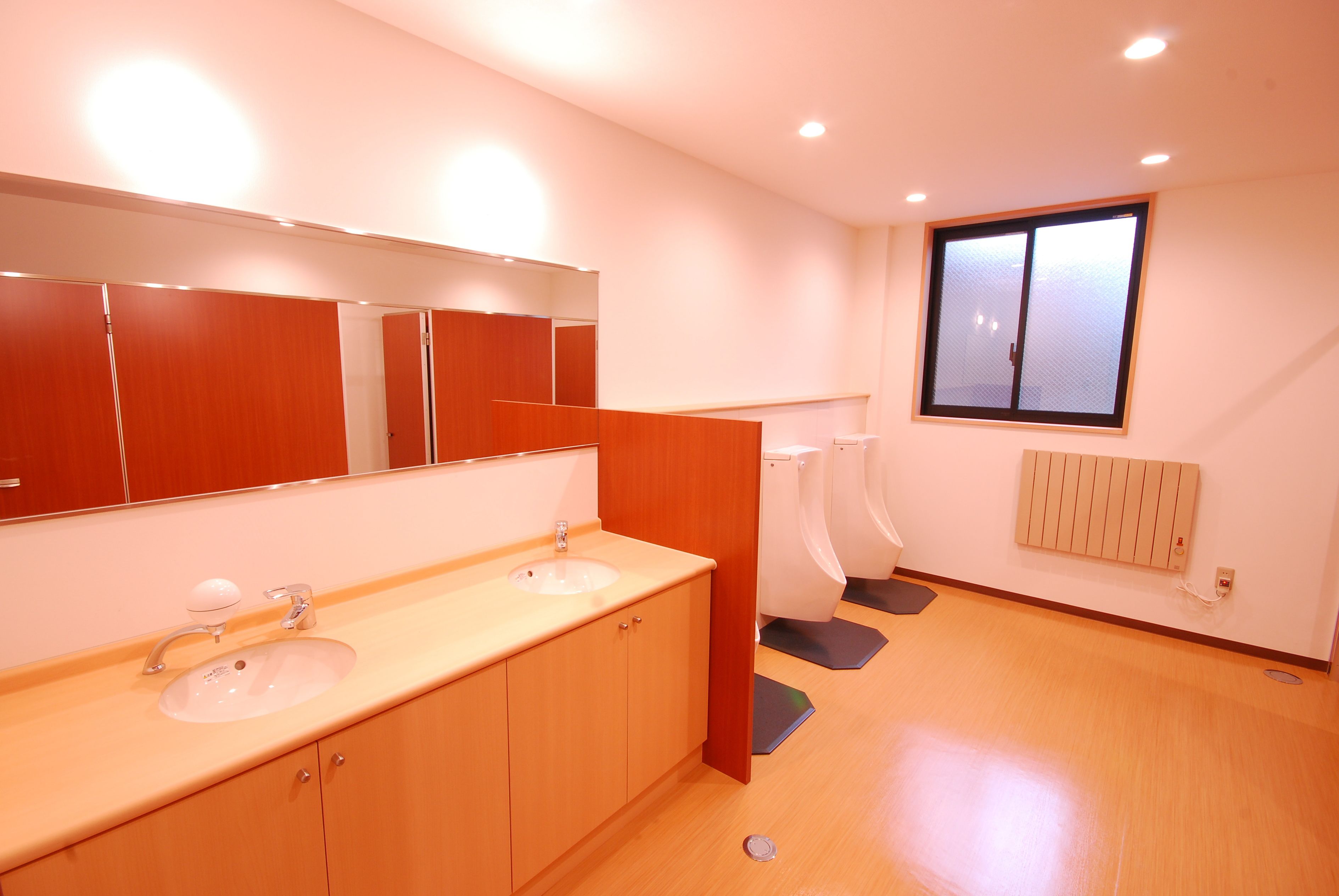 Une salle de bain moderne avec deux lavabos, un grand miroir et une fenêtre.