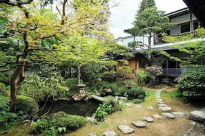 A traditional Japanese garden with a pond, stepping stones, and a stone lantern. - Koyasan Syukubo Zofukuin (Koya)