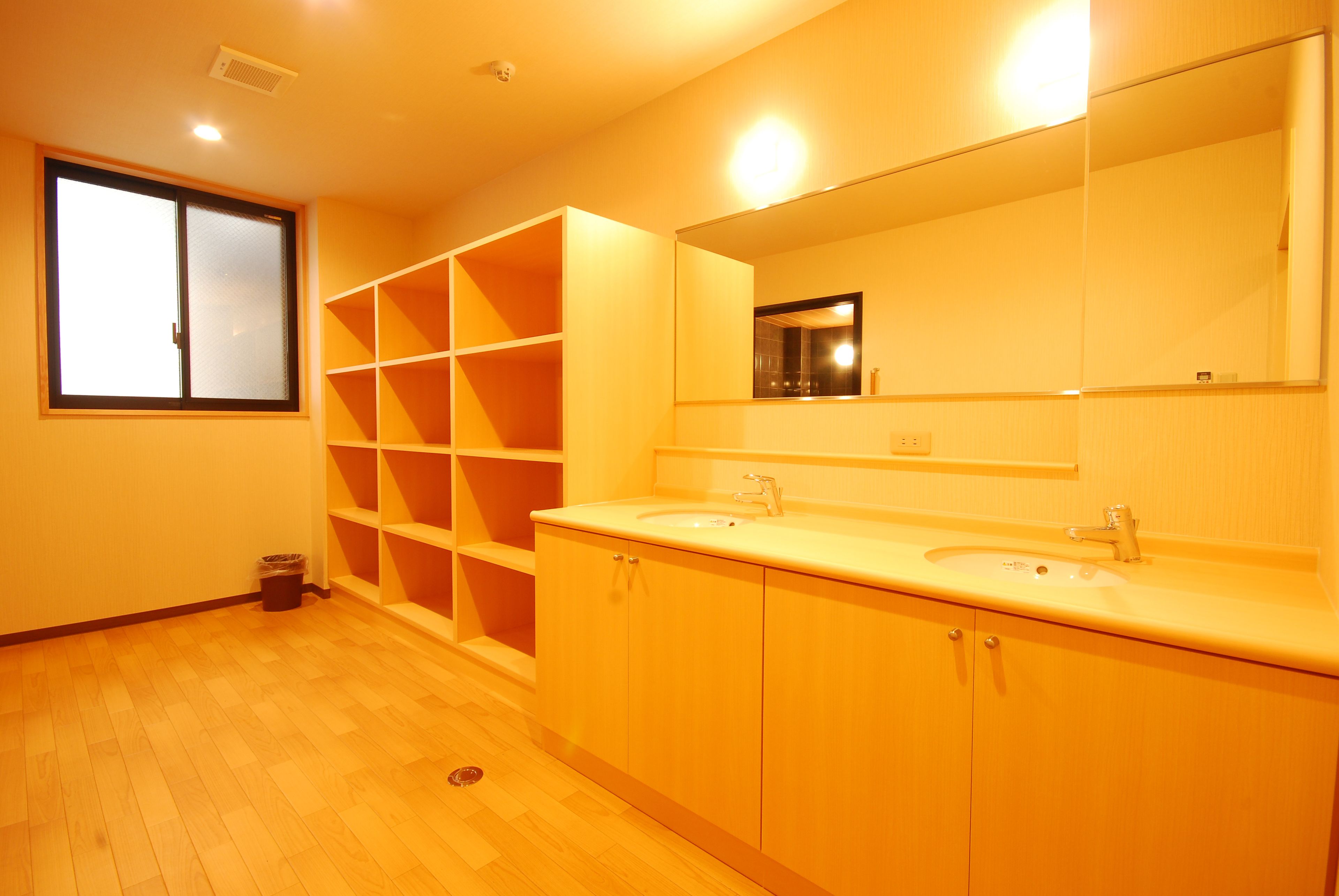 A bathroom with two sinks, a large mirror, and built-in shelving.