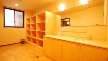 A bathroom with two sinks, a large mirror, and built-in shelving.