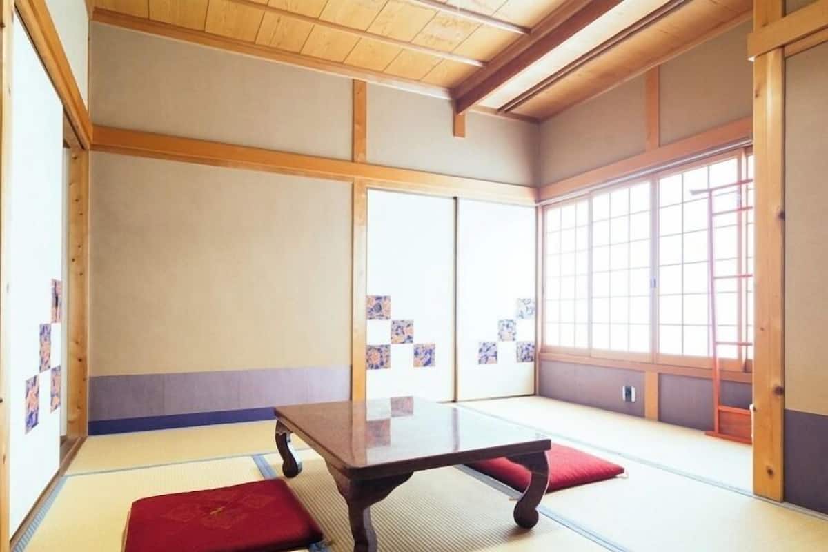 Une pièce de style japonais traditionnel, avec un sol recouvert de tatamis, une table basse et des portes coulissantes.