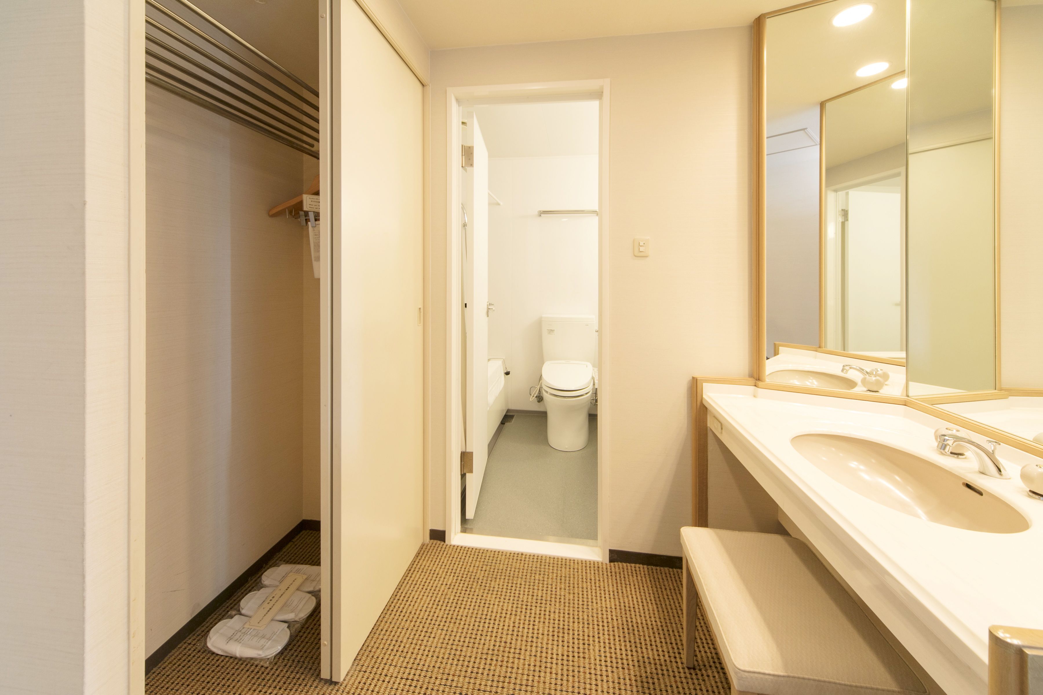 Un baño con lavamanos, espejo y retrete.
