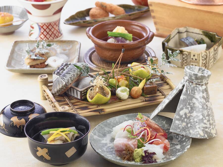 A variety of dishes and utensils on a table, including bowls, plates, and a teapot.