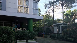 A modern building with a sign reading "LINK" and a green pillar. - The Link Onnut by May (Bangkok)