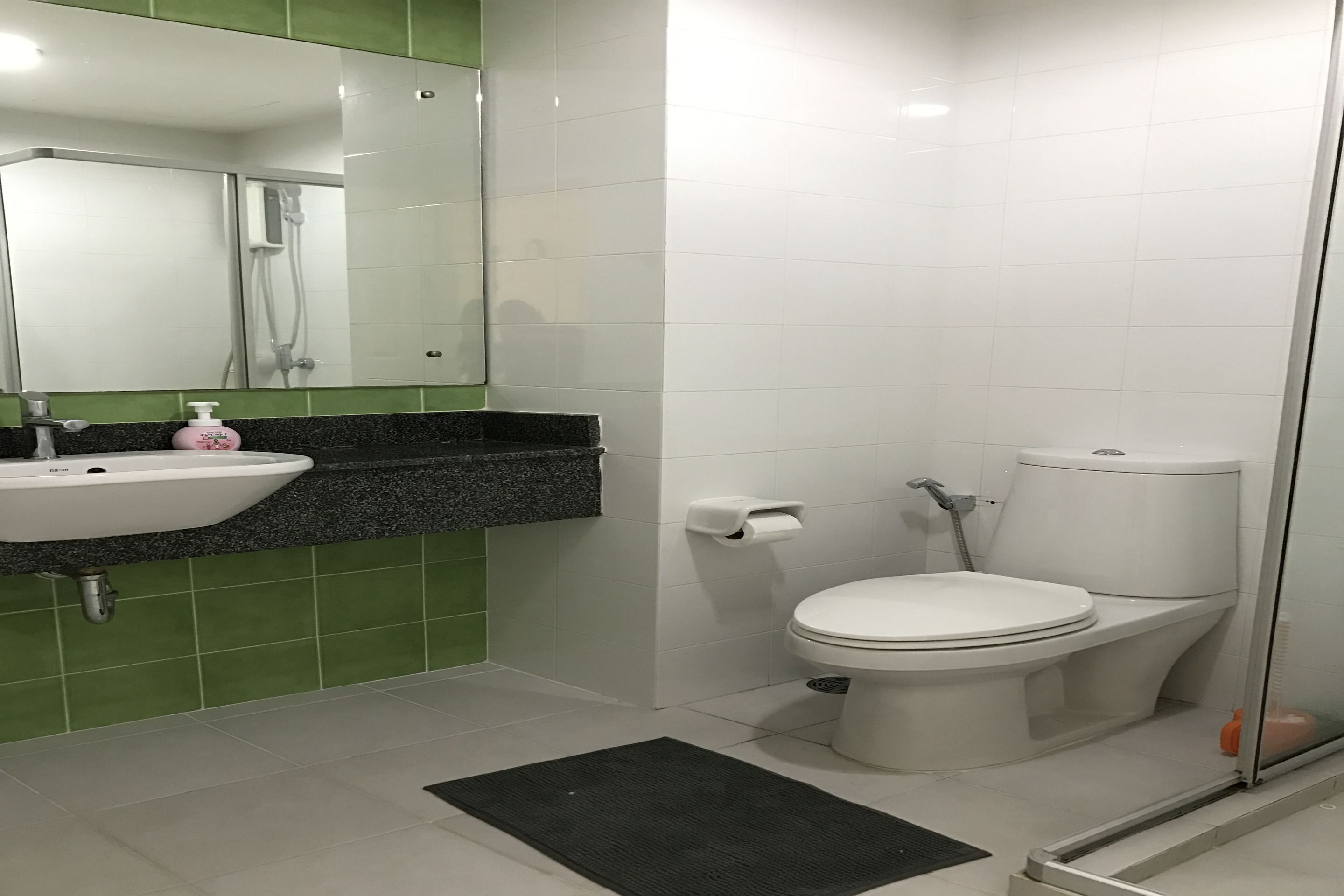 A bathroom with a white sink, toilet, and shower.