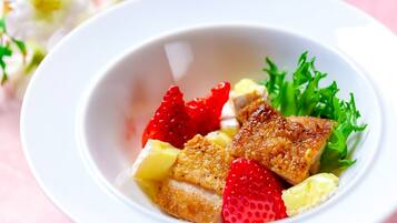 A bowl of food with strawberries, pineapple, and lettuce.