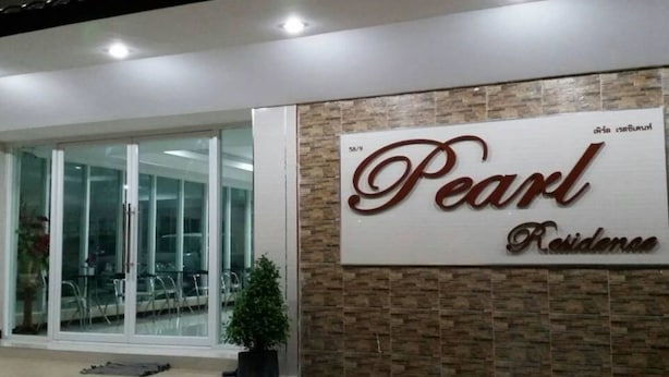 A hotel entrance with a large sign reading "Pearl Residence."