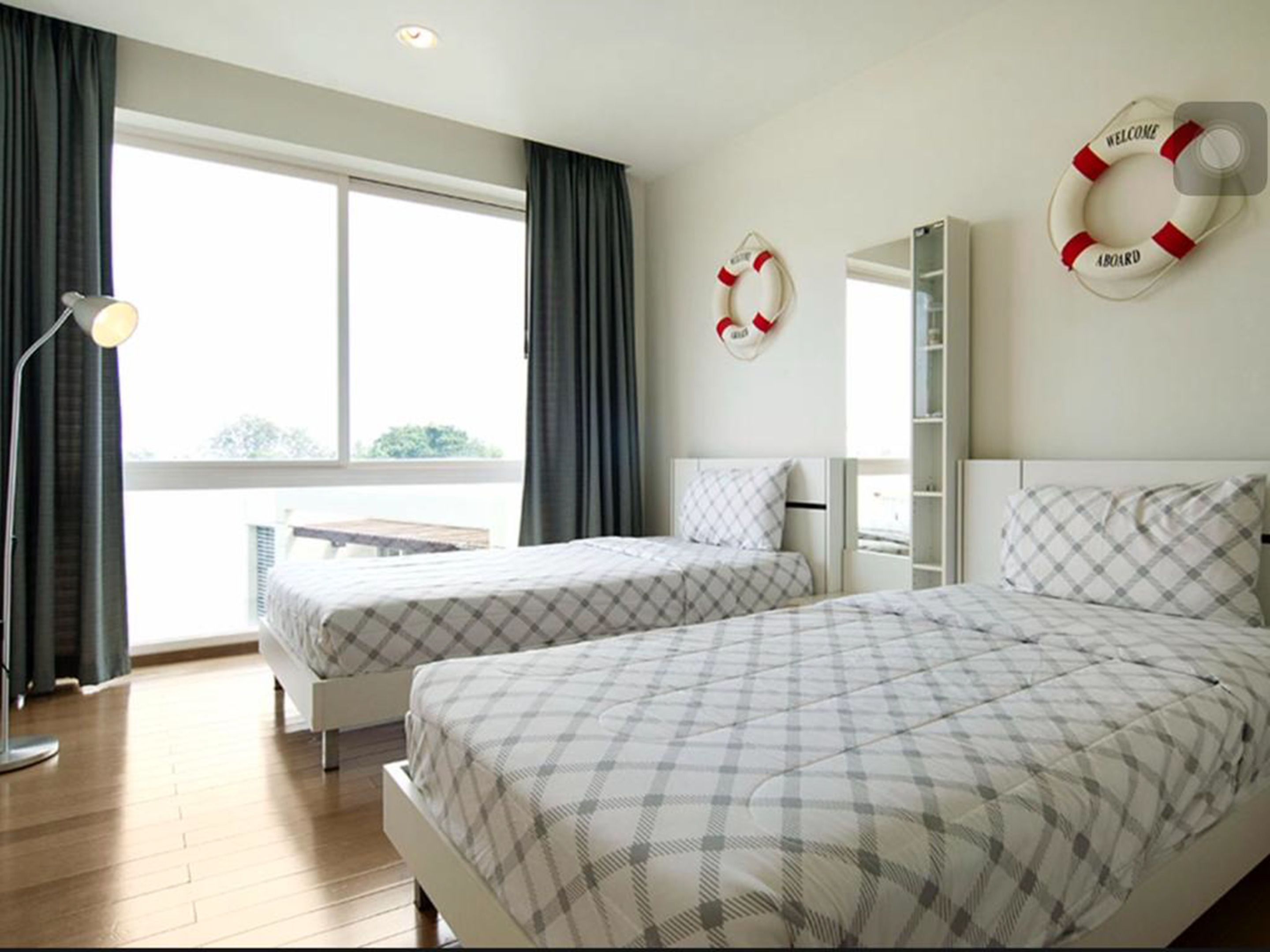 Habitación de hotel con dos camas, un escritorio y un balcón.