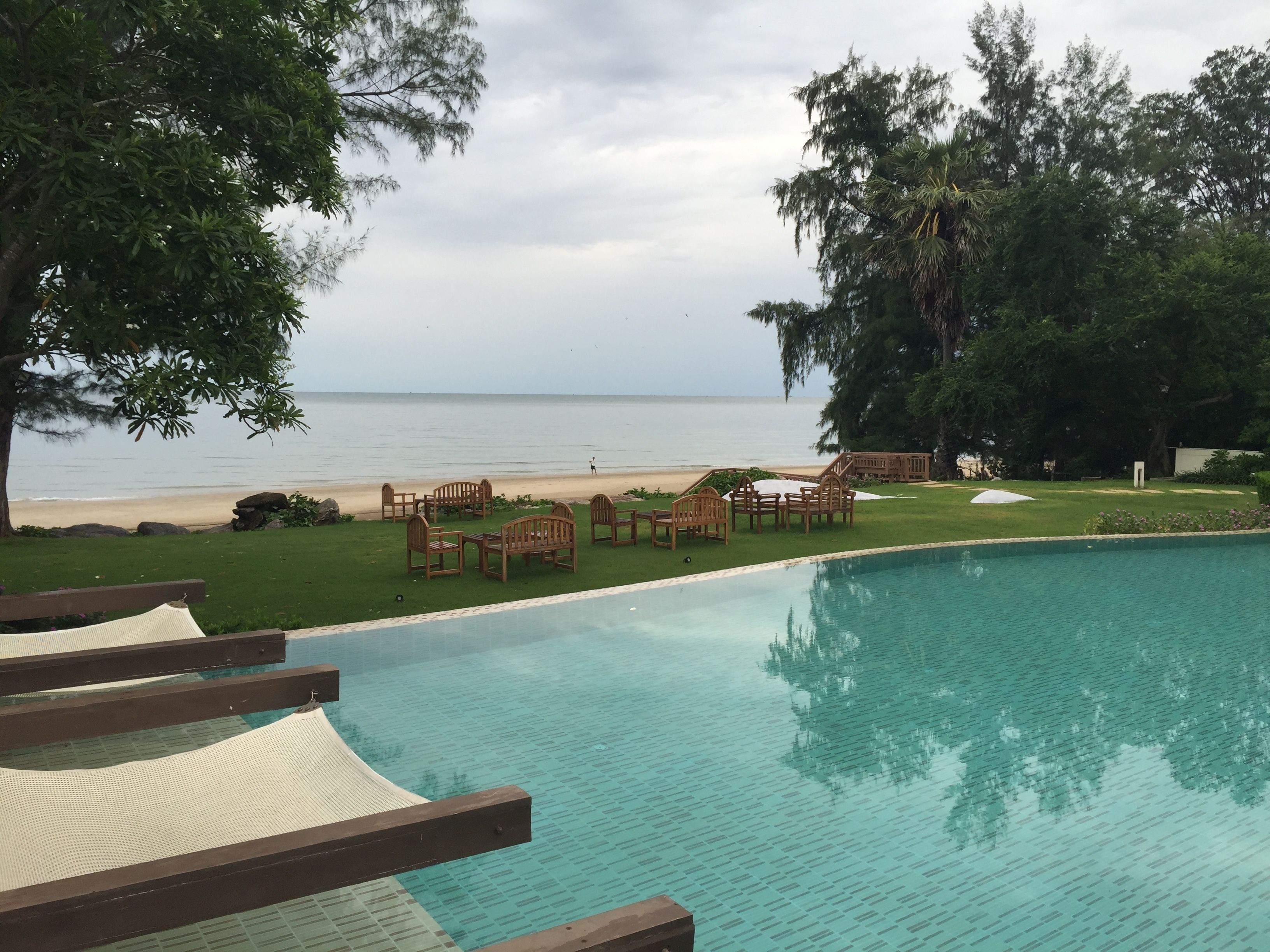Zona junto a la piscina con vista a la playa y al océano.