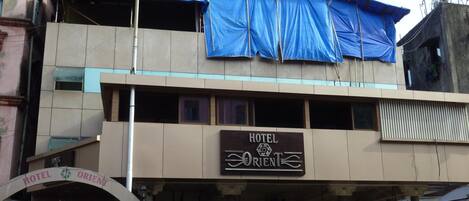 A two-story building with a sign for 'Hotel Orient' on the ground floor.