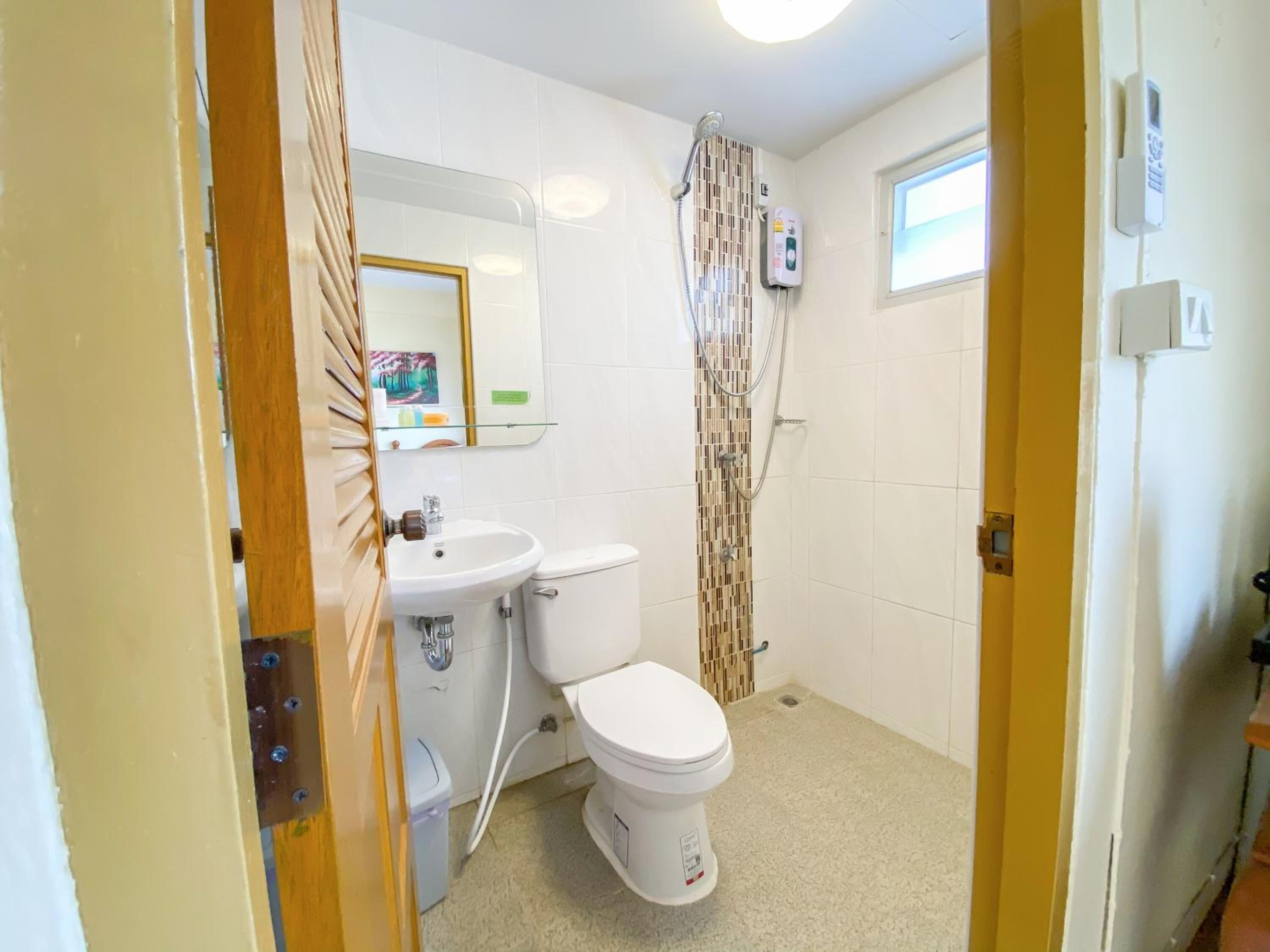 A bathroom with a toilet, sink, and shower.