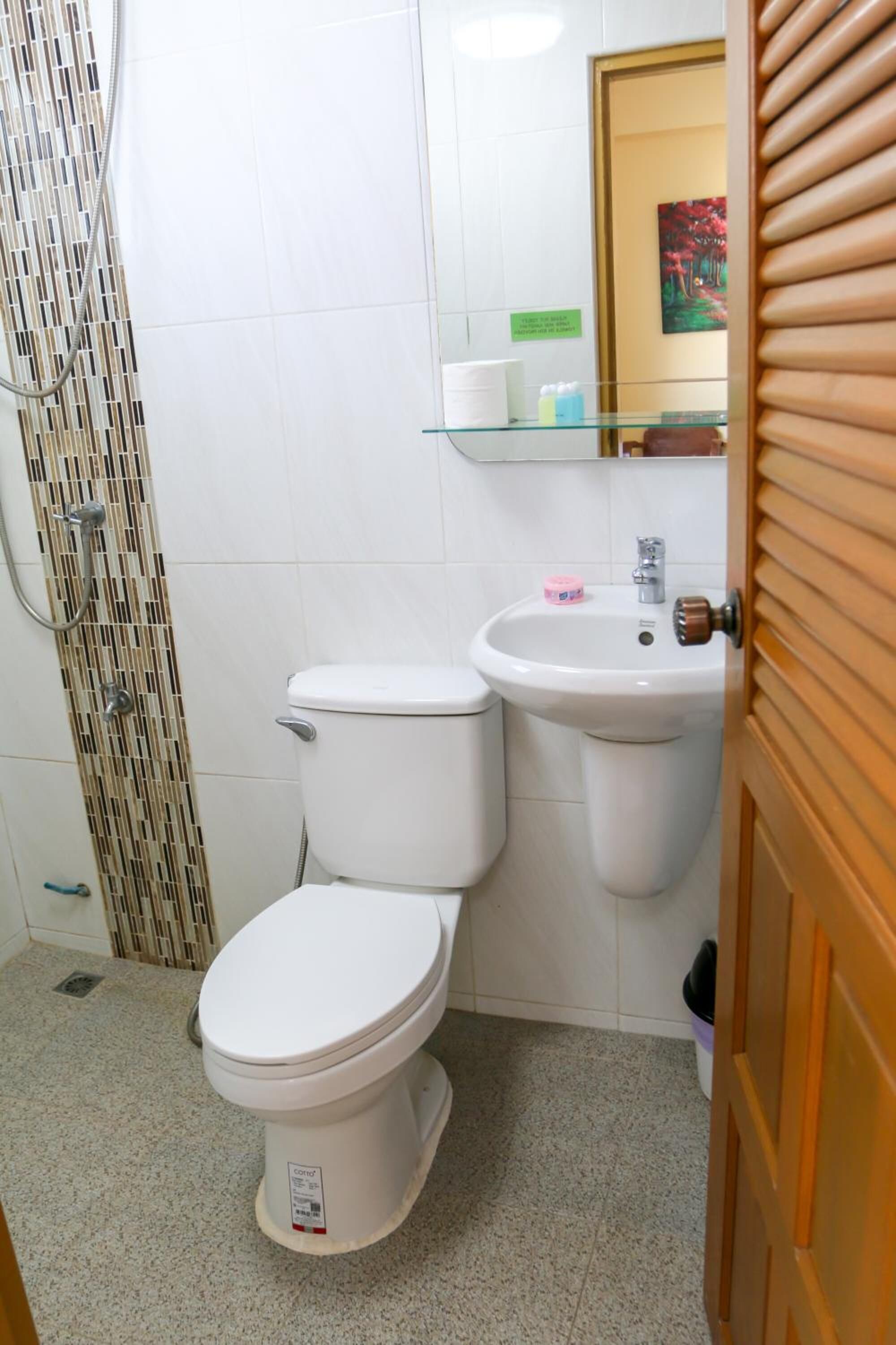 A bathroom with a toilet, a sink, and a shower enclosure.