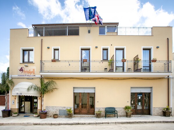 A two-story building with a balcony, potted plants, and a sign that reads "Friskell". - Triskell Camere & Relax (San Vito Lo Capo)