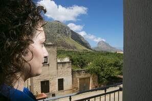 A balcony with a view of a mountain and a building with a rustic appearance. - Triskell Camere & Relax (San Vito Lo Capo)