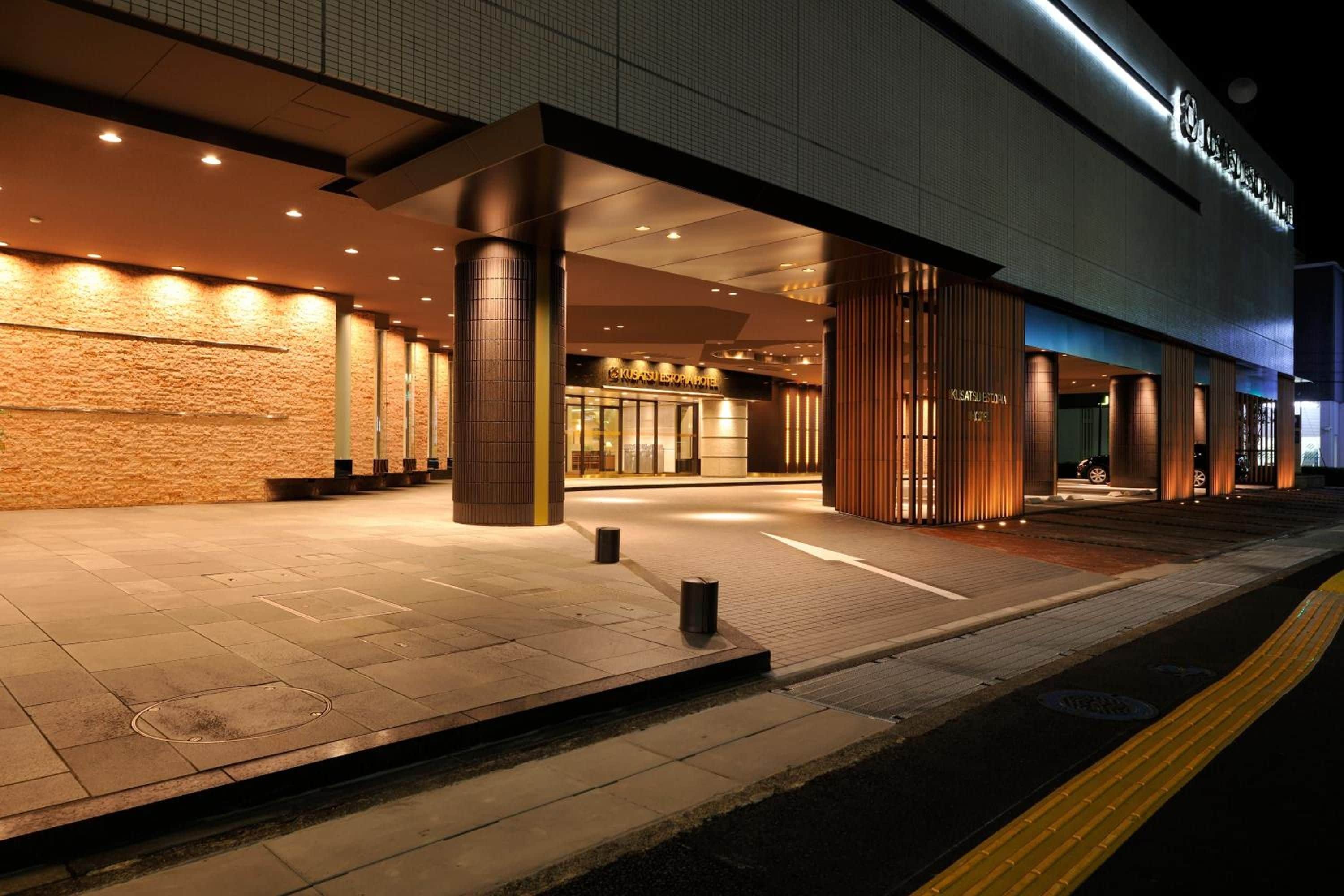 L’entrée d’un hôtel au design moderne, caractérisée par une façade en briques et de grands piliers.