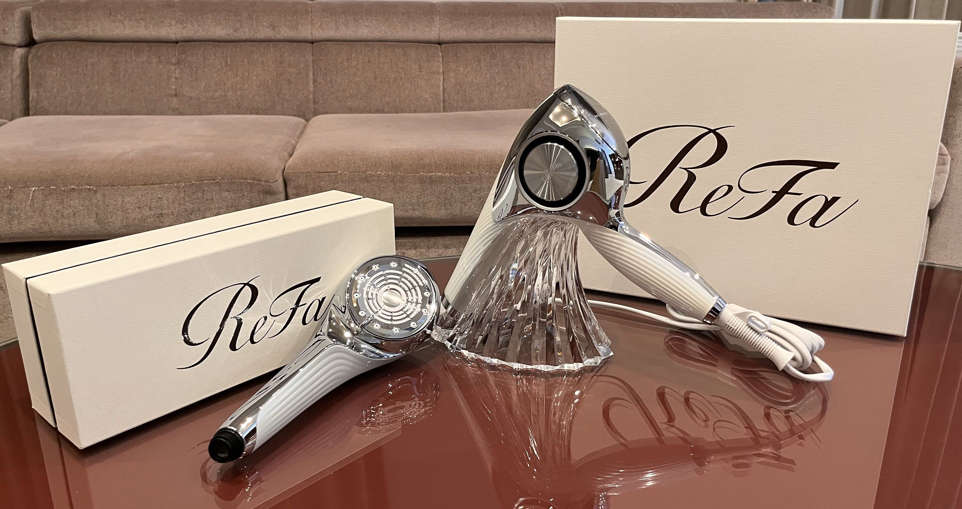 Une table avec un objet décoratif, une boîte et une carte sur laquelle est inscrit le mot « ReFa ».