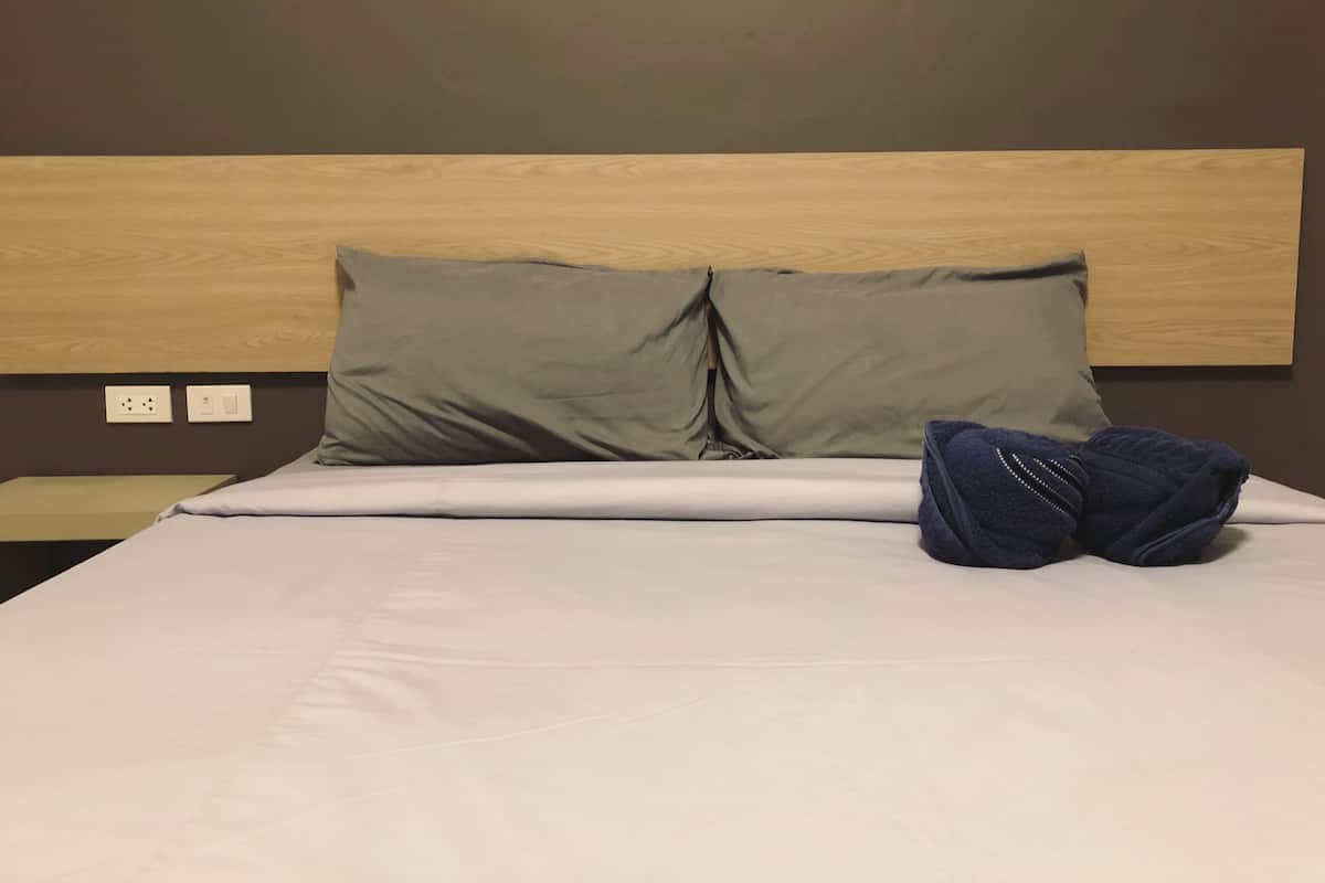 A neatly made bed with two pillows and a folded blanket.