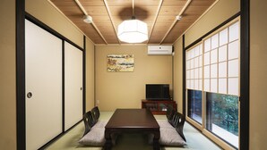 A traditional Japanese-style room with tatami flooring, a low table, and sliding doors.