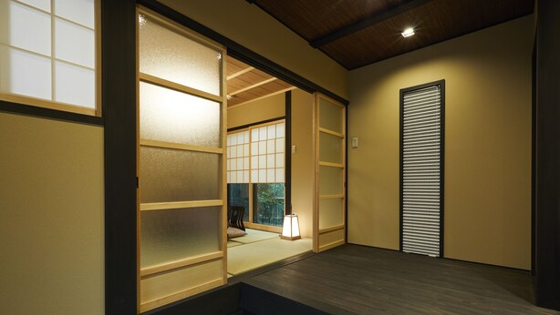 A traditional Japanese room with sliding doors, a tatami mat floor, and a shoji screen.