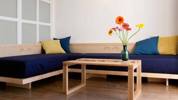 Una sala de estar moderna con dos sofás, una mesa de centro de madera y un jarrón con flores.