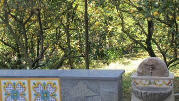 A stone bench with a decorative tile panel and a stone fountain.