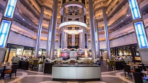A spacious lobby with a central circular seating area, multiple levels of balconies with plants, and a large chandelier. - Ambassador City Jomtien Pattaya - Marina Tower Wing (Sattahip)
