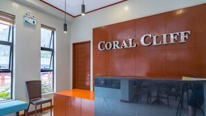 A reception area with a sign reading "CORAL CLIFF". - Coral Cliff Hotel (El Nido)
