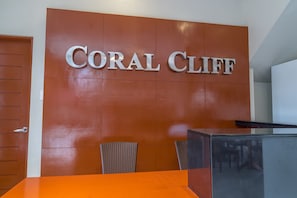 Welcome to Coral Cliff, where guests can check in at the reception desk, surrounded by a clean and contemporary atmosphere.