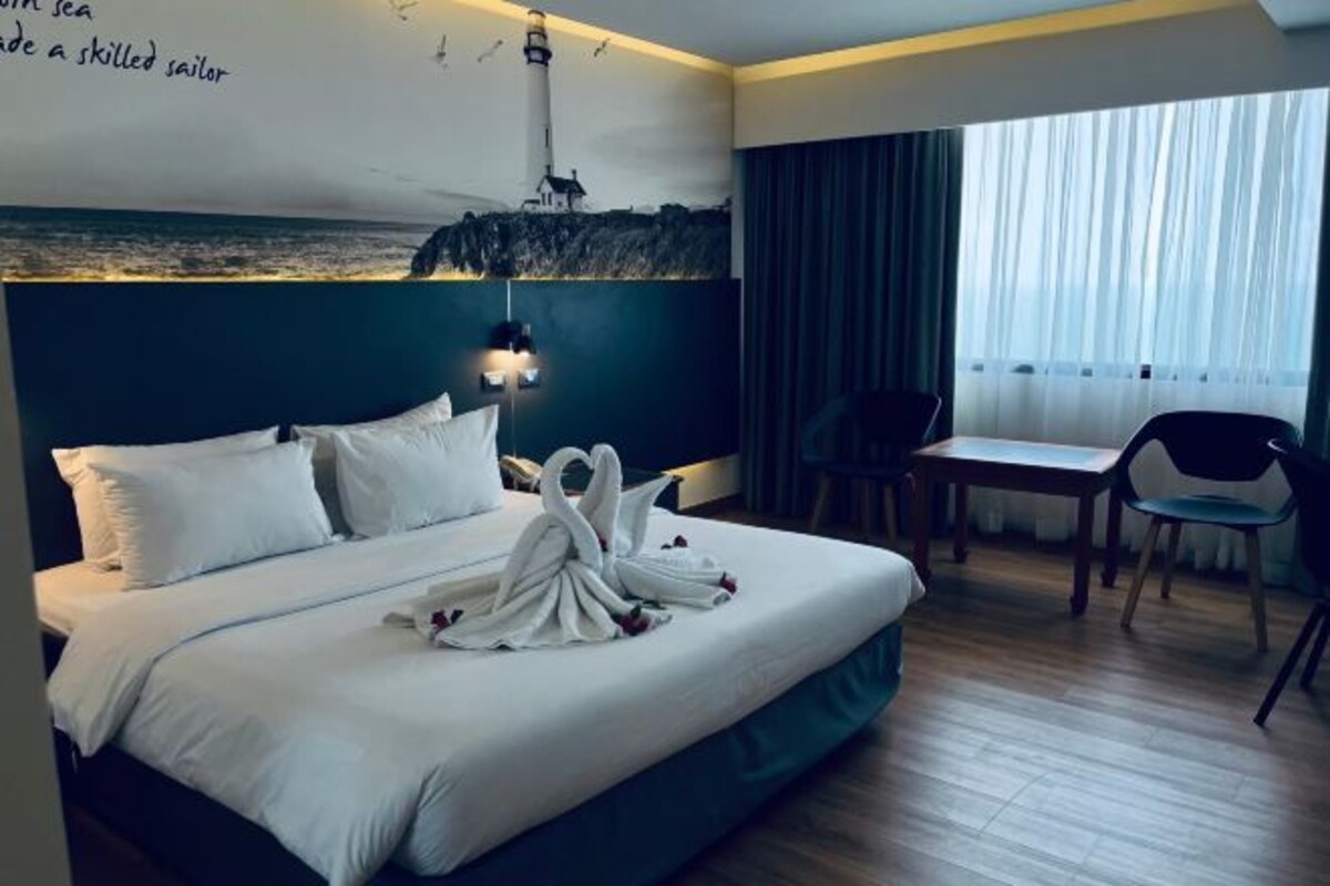 Una habitación de hotel con una cama, un escritorio y una silla.
