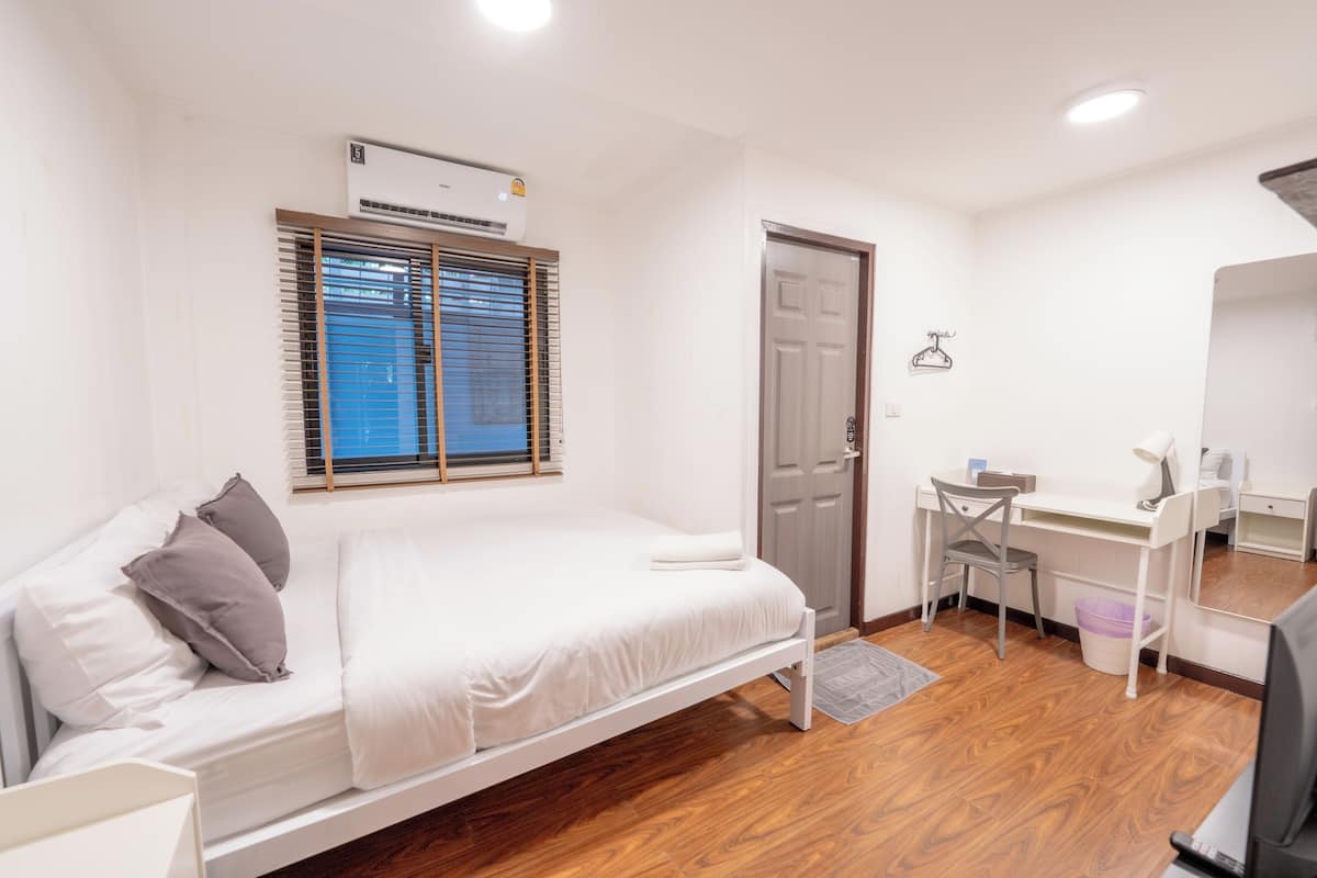 Quarto com cama, escrivaninha, cadeira e guarda-roupa.