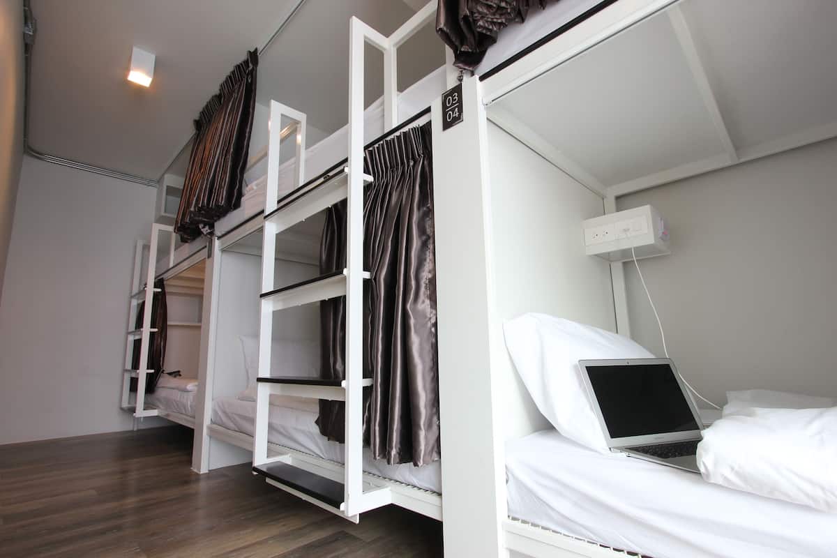 Quarto com beliche e um laptop no camarote inferior.