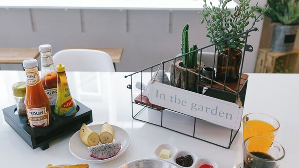 Une table de petit-déjeuner avec des toasts, des œufs, des condiments et une tasse de café.