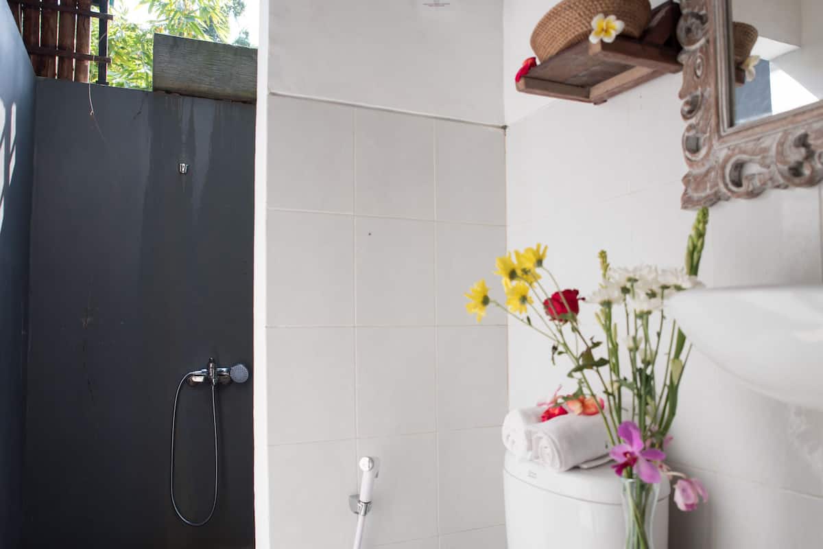 A bathroom with a shower, a toilet, and a sink with a mirror.