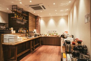 A restaurant with a wooden counter, shelves with glasses and bottles, and a coffee station.