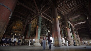 Una gran estructura de madera con techos altos y columnas, probablemente un edificio histórico o de interés cultural.