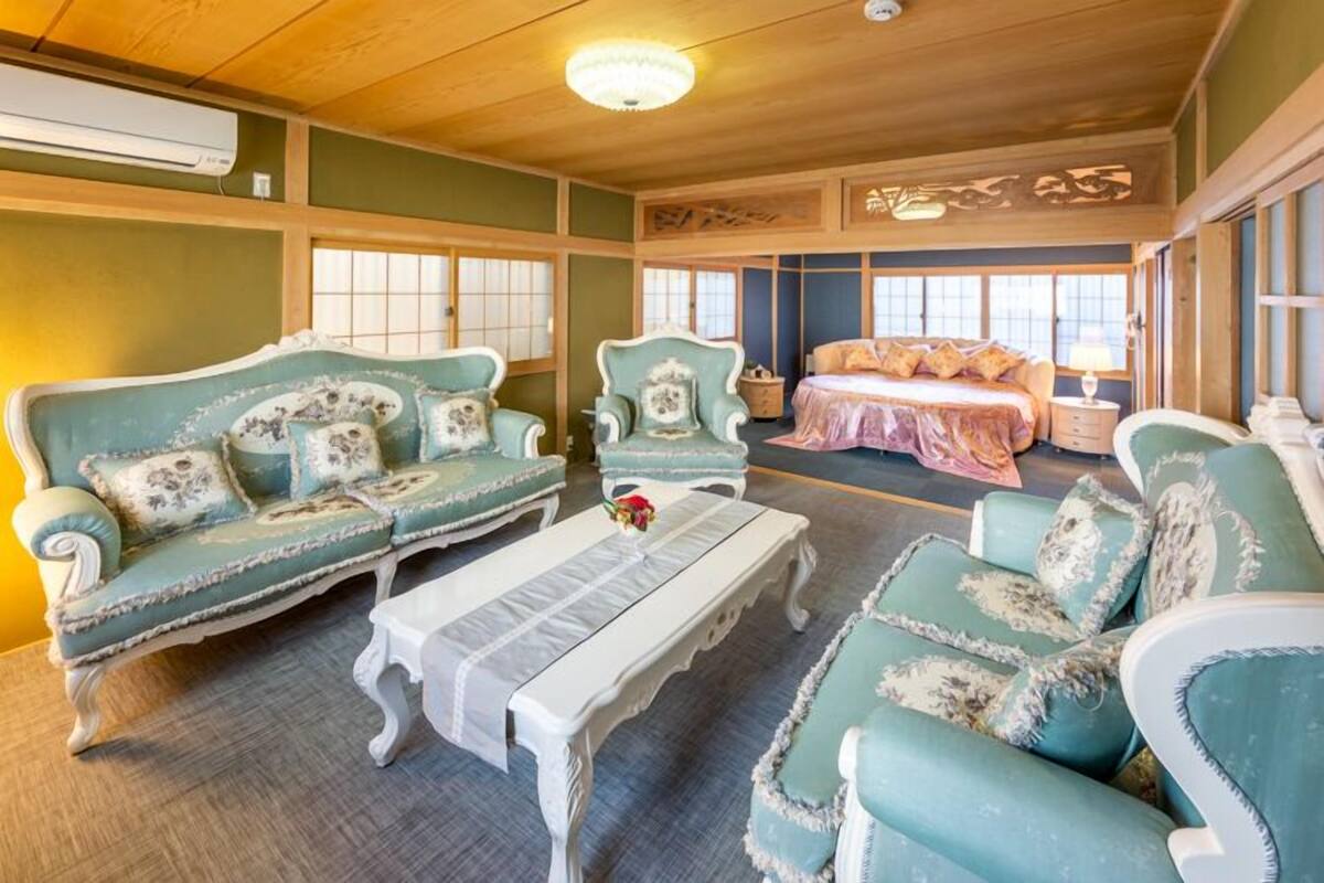 A traditional room with a sofa set, a bed, and a table.