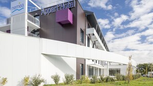 Un hôtel moderne, reconnaissable à son grand panneau « Appart », à sa façade blanche et à sa zone avec balcon.