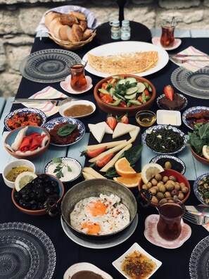 Una mesa con diversos platos, como una ensalada, queso, aceitunas y un plato de huevos.