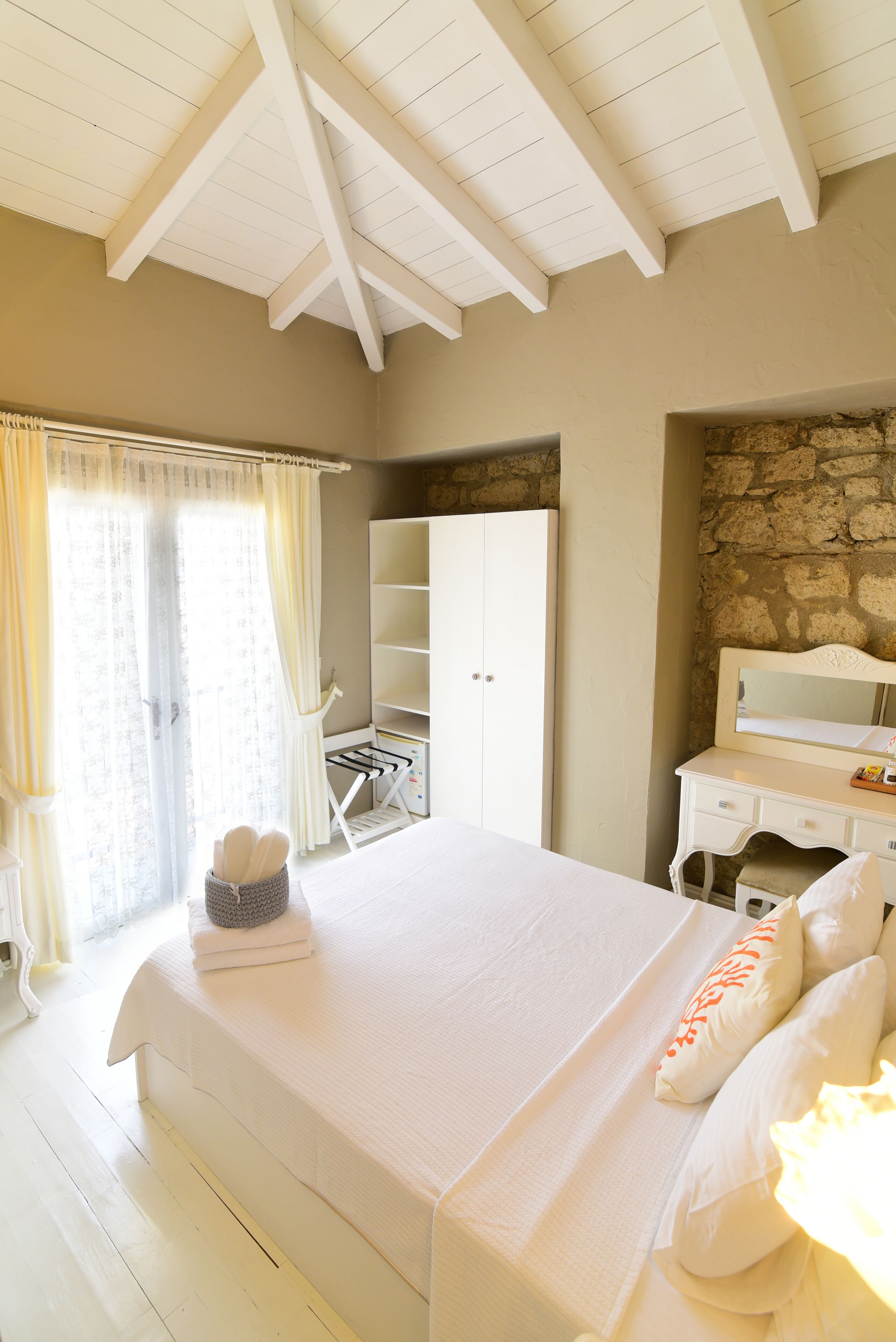 Une chambre à coucher comprenant un lit, une commode, un miroir et une armoire.