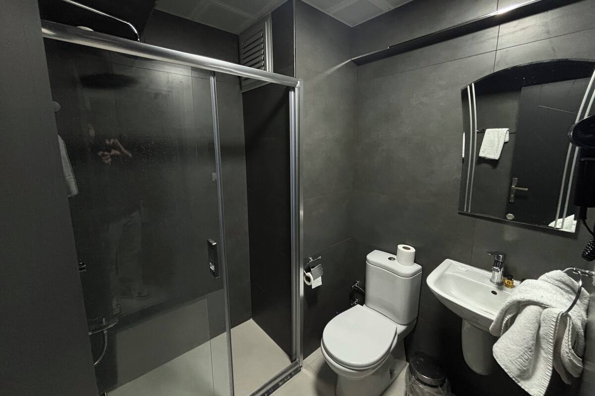 Une salle de bain moderne avec une douche à parois de verre, des toilettes et un lavabo.