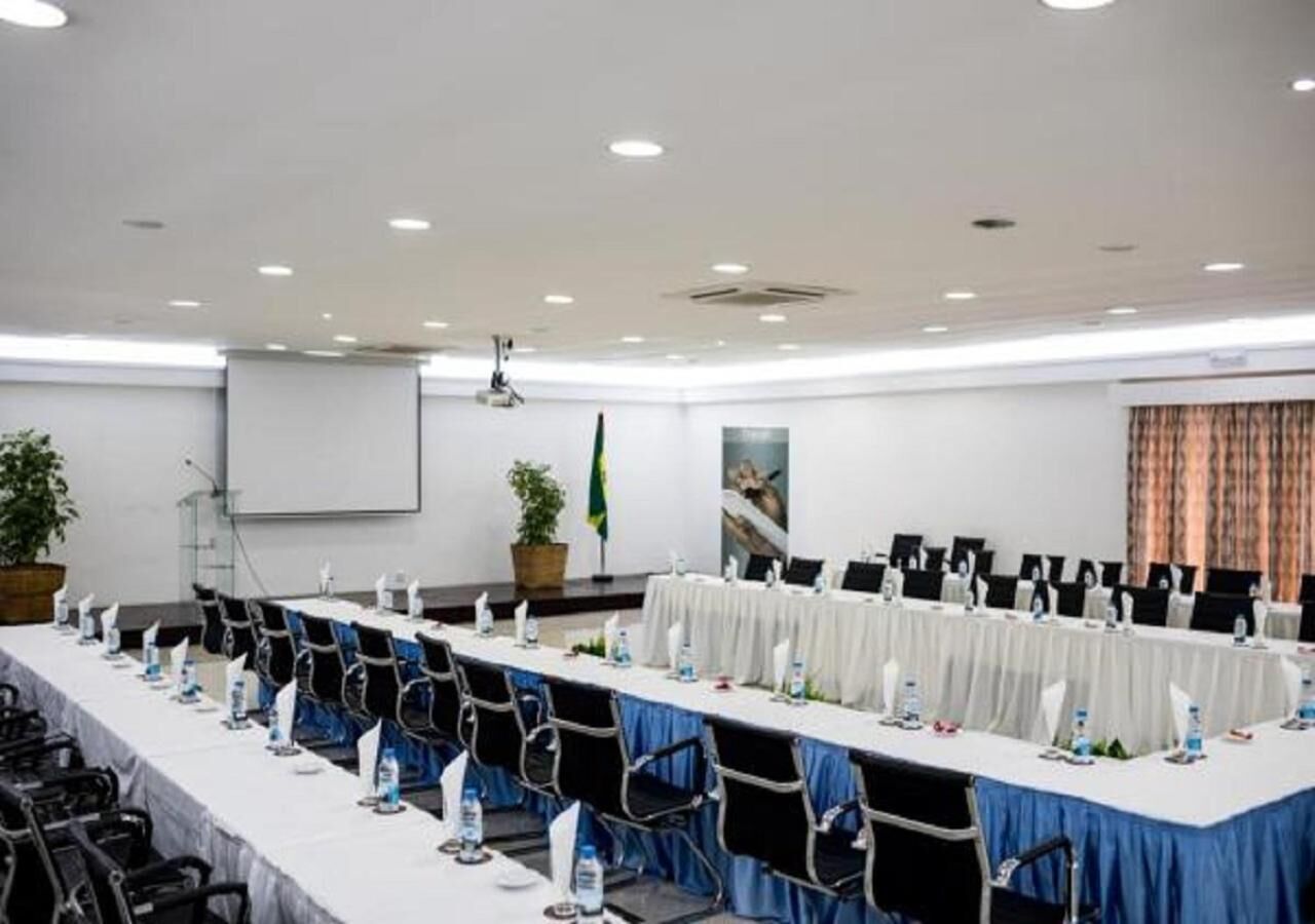 Une salle de conférence équipée d’une longue table, de chaises et d’un écran de projection.