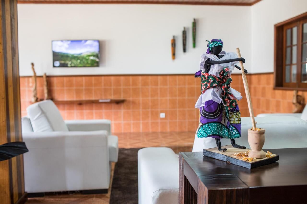 Una habitación con muebles blancos, un televisor en la pared y una figura decorativa.