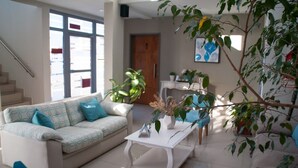 A modern living room with a sofa, coffee table, and potted plants. - Links Apart Hotel (Río Grande)